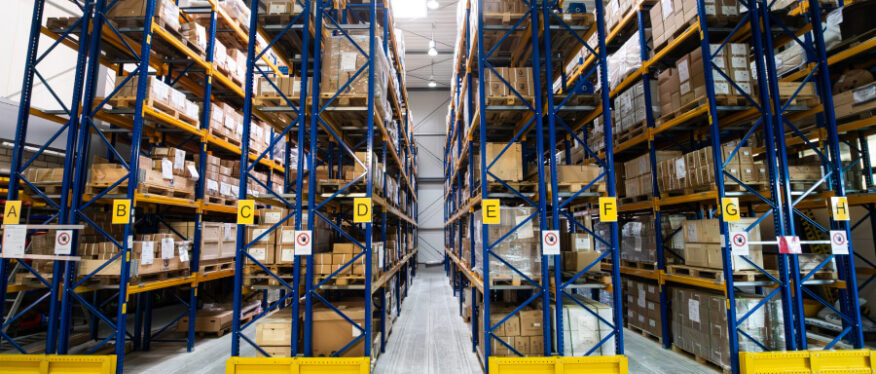 Hochregallager bei PLANETA mit beschrifteten Lagergassen – Teil des After-Sales-Service für Ersatzteillogistik