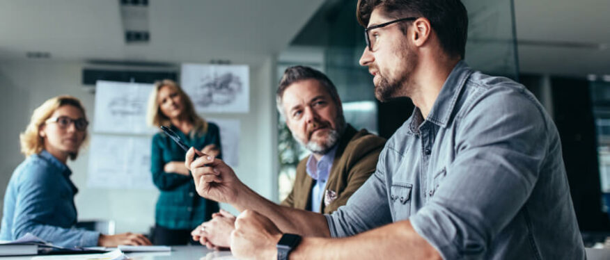 Zwei Personen lächeln gemeinsam bei einer Beratung vor einem Laptop.