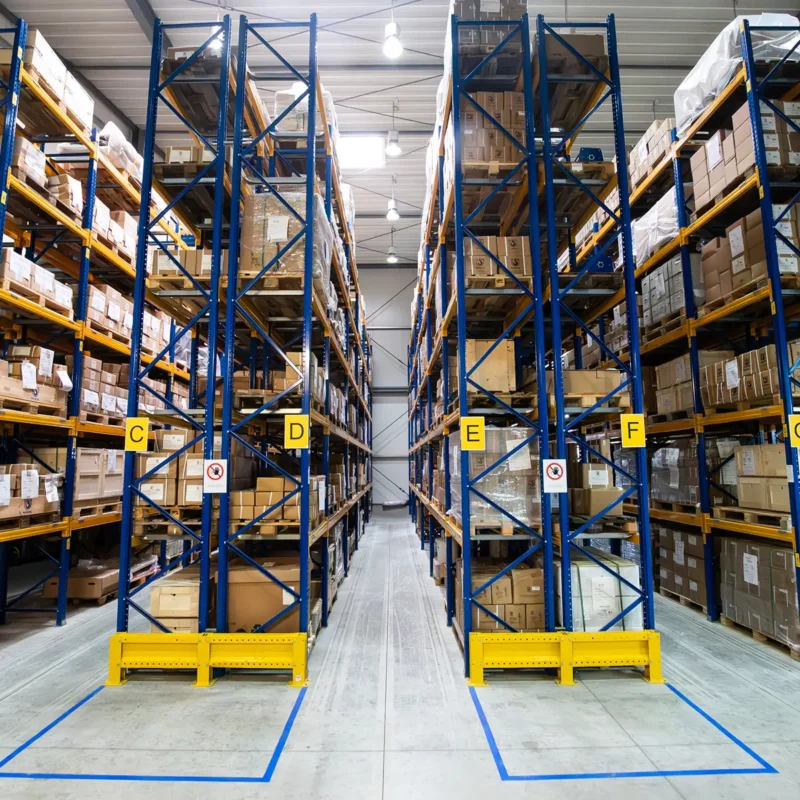 Hochregallager bei PLANETA mit beschrifteten Lagergassen – Teil des After-Sales-Service für Ersatzteillogistik