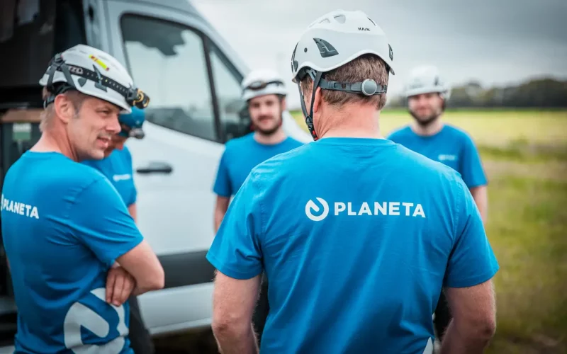 PLANETA-Team mit Helmen bei Einsatzbesprechung neben Transporter – Sicherheit, Planung & Einsatzkoordination